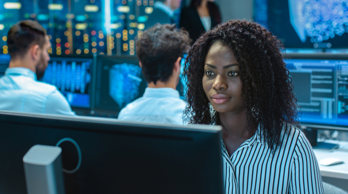 racismo e tecnologia: como combater? Na imagem mulher negra cientista de dados encara tela de computador. 